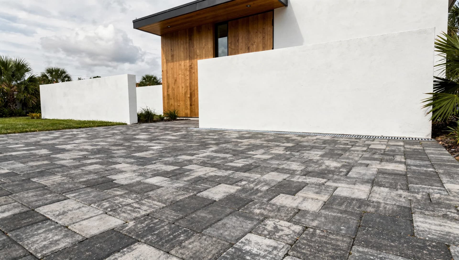 Charcoal paver forecourt beside a contemporary entrance
