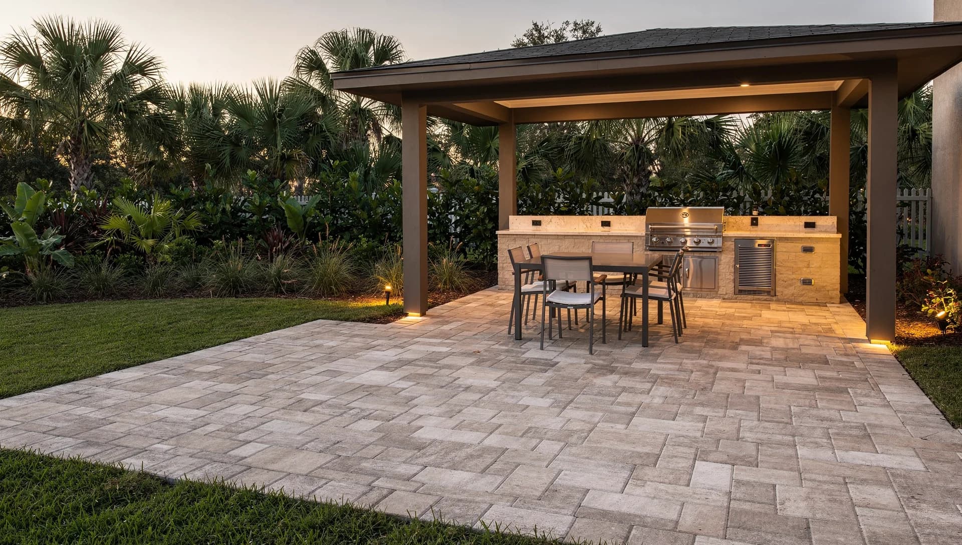 Sand-toned terrace and covered outdoor kitchen at evening